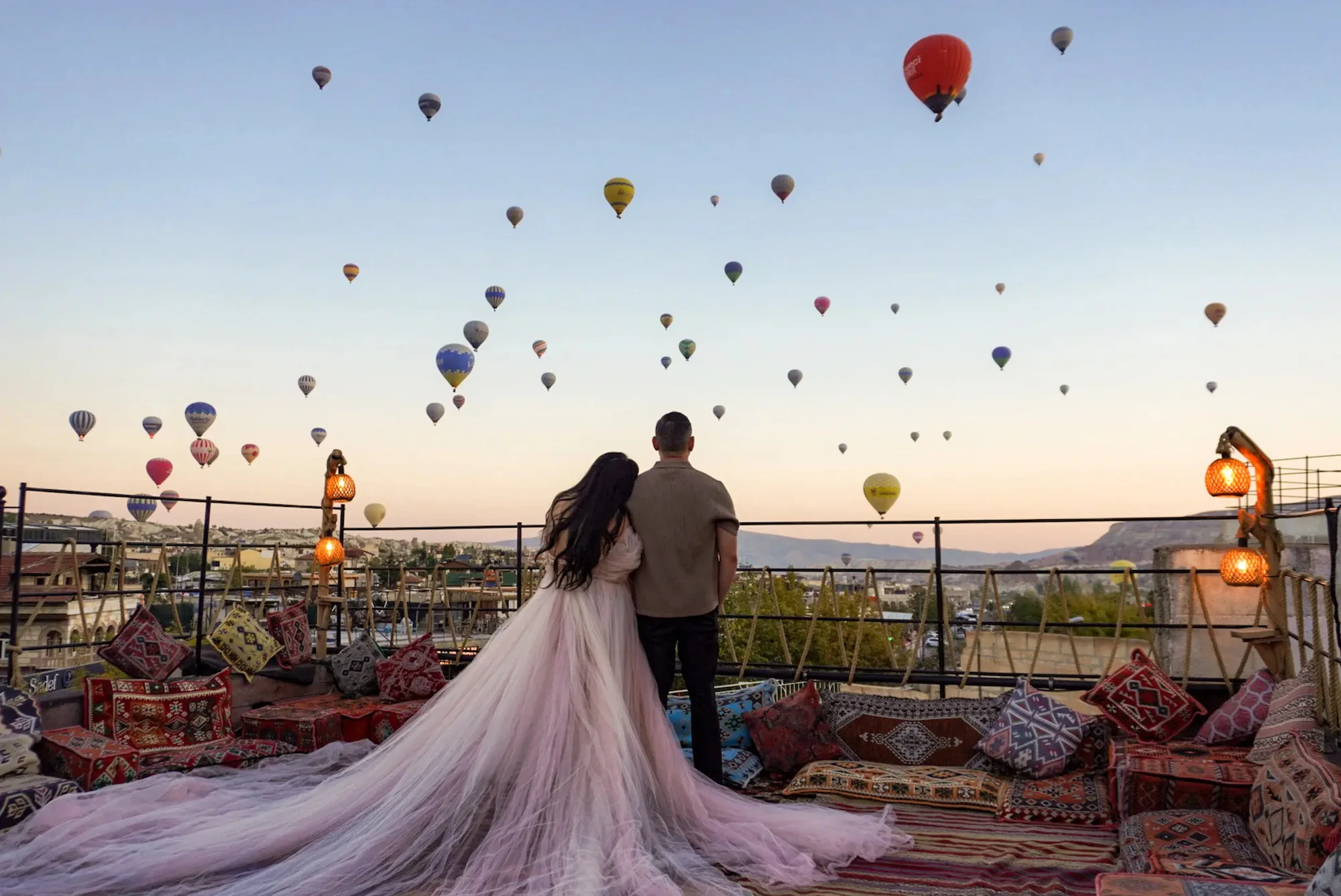 A couple under the balloons on the rooftop